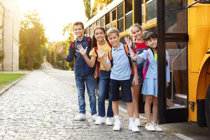Students waving in front of an SLN bus